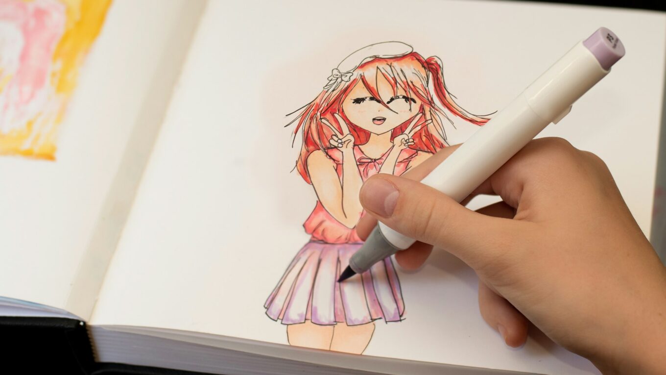 Girl's hand drawing anime manga sketch with alcohol based sketch markers.